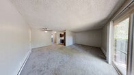 Located at 4455 NE 12th St in Renton, WA, this single-floor residence offers three bedrooms and one bathroom within a thoughtfully arranged floor plan. Throughout the home, soft neutral-toned carpeting and light gray walls create a clean, cohesive aesthetic. Textured ceilings are consistent throughout, adding a classic character to each room.

The spacious primary bedroom is a standout feature of this home, offering generous proportions well-suited for a full furniture arrangement. It includes a sliding glass door that opens to a private patio, inviting natural light and outdoor access. A baseboard heater ensures year-round comfort. The two additional bedrooms are well-sized, each carpeted and featuring windows that bring in natural light. One bedroom includes a closet and direct hallway access, while another benefits from a sliding closet and an in-unit stacked washer and dryer — a highly practical convenience.

The bathroom is clean and functional, featuring a full-size soaking tub and shower combination with chrome fixtures. The kitchen, visible in the dollhouse view, features dark cabinetry and flows into the main living areas. A ceiling fan in the central living area enhances airflow throughout. Baseboard heating is present in multiple rooms, providing consistent warmth. The layout is connected by a central hallway, making navigation between rooms efficient and straightforward.