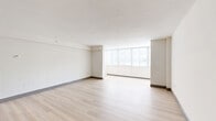 Located in the heart of Orlando along South Lucerne Circle, this 2-bedroom, 1-bathroom residence offers a thoughtfully designed single-floor layout with a clean, modern aesthetic. The open-concept living and dining area is a standout feature, showcasing light wood flooring, crisp white walls, and a wide bank of windows that flood the space with natural light and offer views of the surrounding area. The seamless flow between the living, dining, and kitchen zones makes the layout feel expansive and functional.

The kitchen is well-appointed with white shaker-style cabinetry, quartz countertops, a subway tile backsplash, stainless steel appliances including a refrigerator, range, microwave, and dishwasher, and a double-basin sink with a matte black faucet. Light wood flooring continues through the kitchen, tying the space together cohesively.

Both bedrooms are carpeted for comfort and each features a ceiling fan with lighting and a window allowing natural light. The primary bedroom offers a generous footprint with ample room for furnishings. Five closets throughout the unit provide exceptional storage capacity. A hallway connects the private areas of the home, ensuring a practical and organized floor plan throughout.