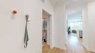 Located on E Colonial Drive in Orlando, Florida, this single-level 2-bedroom, 2-bathroom residence offers a well-organized, modern layout designed for comfortable everyday living. Light wood-look flooring runs throughout, tying each room together with a clean, cohesive aesthetic.

The living room is bright and welcoming, featuring large windows that invite ample natural light and views of the outdoors. A soft, neutral color palette with sage-green accent walls adds depth and warmth to the space. The kitchen is a standout feature, equipped with stainless steel appliances, flat-front cabinetry in white and light gray, white quartz countertops, and a distinctive teal hexagonal tile backsplash — a bold design touch that elevates the room.

The primary bedroom connects directly to its en-suite bathroom, which includes a walk-in glass shower, a white vanity with modern hardware, and wood-look flooring. A dedicated walk-in closet with built-in shelving provides organized storage. The second bedroom is equally well-lit, benefiting from natural light through large windows. The second bathroom features a soaking tub with subway tile surround and a clean white vanity. A hallway with a wall-mounted hook offers a practical entryway moment, completing this efficiently designed and stylishly finished residence.