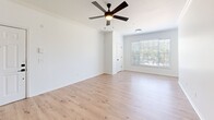 Located at Gables Commons in Orlando, Florida, this 2-bedroom, 1-bathroom single-story residence offers a clean, modern aesthetic throughout. Light wood-style flooring flows seamlessly across every room, complemented by crisp white walls and white trim that create a bright, cohesive interior.

The open-concept kitchen and dining area serves as the heart of the home, anchored by a central island with a quartz countertop and undermount sink. White shaker-style cabinetry with matte black hardware lines the walls, paired with a classic subway tile backsplash and a full suite of stainless steel appliances, including a refrigerator, electric range, and over-the-range microwave.

The spacious living room benefits from natural light streaming through large windows with blinds and is accented by crown molding and a ceiling fan with integrated lighting. The generously sized primary bedroom features its own window with outdoor views and direct closet access, while the second bedroom is equally well-lit with a bright window and ample floor space. Three closets throughout the unit provide substantial storage.

A dedicated laundry room with a full-size washer and dryer adds everyday convenience. The hallway connects all spaces efficiently, contributing to an organized and functional layout. The overall ambiance is fresh, neutral, and move-in ready.