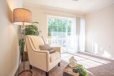 Located at 1056 Centerbrooke Lane in Suffolk, Virginia, this single-floor home offers a practical and comfortable layout designed for everyday living. The floor plan reveals a well-organized arrangement of rooms that flow naturally from one to the next.

The bedrooms are carpeted in warm, neutral tones and filled with natural light from large windows dressed with blinds. Each room features ceiling fans and ample space, with one bedroom offering an adjoining closet and views into a connected bathroom area.

The kitchen is efficiently designed with light wood cabinetry, dark stone-style countertops, and stone-look tile flooring. White appliances including a range, microwave, and dishwasher are neatly integrated, and a pendant light above the adjacent area adds a welcoming touch. The layout allows for easy movement and connectivity to the neighboring living areas.

Two bathrooms continue the stone-look tile flooring theme, maintaining a consistent aesthetic throughout. One features a walk-in shower with grab bars, while the other includes a full tub-shower combo, both finished with light wood vanity cabinetry.

Additional living areas feature plush carpeting, neutral wall tones, and ceiling fans, creating versatile spaces suitable for relaxation or a sitting room. Clean lines, soft finishes, and consistent design choices throughout give this home a tidy, move-in-ready character.