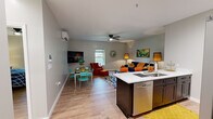 Located at 750 Lakeview St in Bristol, Tennessee, this single-floor residence offers a thoughtfully designed open-concept layout across two bedrooms, one bathroom, and a utility room. Light hardwood flooring flows throughout, complementing the neutral gray-toned walls and bright white trim.

The combined kitchen and living area forms the heart of the home. The kitchen features a large island with a quartz waterfall countertop, an undermount sink with a gold-finish faucet, stainless steel appliances including a French door refrigerator, electric range, and microwave, plus white upper cabinetry with a stone tile backsplash. A dedicated dining area adjacent to the kitchen is served by a wall-mounted mini-split HVAC unit, and a wall-mounted TV adds to the convenience of the space. The living room is anchored by a ceiling fan and benefits from natural light through a window.

Both bedrooms are comfortable and calm, each equipped with a ceiling fan and windows with outdoor views. The primary bedroom includes a walk-in closet with hanging rods and built-in shelving. The shared bathroom offers a marble-top vanity with gold fixtures, an arched mirror, and a shower with a decorative curtain. A separate utility room provides additional storage and functional space.