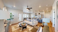 Located in Bixby, Oklahoma, this well-appointed single-story home offers a thoughtfully designed layout across two bedrooms, two bathrooms, and a dedicated office space. The exterior showcases a modern board-and-batten facade with an attached garage and a fenced yard, fitting neatly within a welcoming residential neighborhood.

Inside, the open-concept living, dining, and kitchen area serves as the heart of the home. The living room features warm hardwood-style flooring, a ceiling fan, and recessed lighting, flowing naturally into a bright dining area bathed in natural light from large windows with sheer curtains. The kitchen is well-equipped with light gray cabinetry, stainless steel appliances, a kitchen island with bar seating, and striking geometric pendant lights that add a contemporary touch.

The primary bedroom is a comfortable retreat with a ceiling fan and a spacious walk-in closet offering full-length hanging storage. The second bedroom is equally inviting. Both bathrooms are finished with gray vanities, wood-tone flooring, and tiled tub-shower surrounds. Additional highlights include a pantry, dedicated laundry room, hallway, and a patio for outdoor enjoyment. The home's clean, neutral palette and modern fixtures create a cohesive and functional living environment.