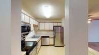 Located at 9741 Grand Ave S in Bloomington, Minnesota, this single-floor unit offers a practical and comfortable layout designed for everyday living. The kitchen is well-appointed with white cabinetry trimmed in warm wood tones, light countertops, and a full suite of stainless steel appliances including an electric range, built-in microwave, dishwasher, and refrigerator. Tile flooring and ample overhead cabinet storage make the kitchen both functional and easy to maintain. A half-wall pass-through connects the kitchen to the living area, creating an open, connected feel. The living room is generously sized, featuring wall-to-wall carpeting, a ceiling fan with light fixture, and a large window that allows natural light to fill the space. The bedroom offers carpeted flooring, a window with an outdoor view, and a double bi-fold closet providing substantial storage. A hallway bathroom includes a full tub and shower combination with clean, neutral finishes. The entry foyer, with its solid wood door, provides a welcoming transition into the home. Textured ceilings and consistent neutral wall tones throughout contribute to a cohesive, understated aesthetic across all rooms.