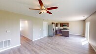 Located at 2575 Gate Dr in Clinton, Iowa, this two-story home offers a well-designed layout across two floors. The main level features an open-concept living and kitchen area with light hardwood-style flooring and a ceiling fan that anchors the spacious living space. Natural light flows in through large windows, offering views of the surrounding greenery. The kitchen is well-appointed with rich dark cabinetry, granite-look countertops, a double-basin sink, and a full suite of stainless steel appliances including a refrigerator with ice maker, electric range, and over-the-range microwave. A hallway on the main level provides access to additional rooms, including a dedicated laundry room equipped with a washer and dryer. Carpeted stairs lead to the upper floor, where all three bedrooms are located. The generously sized primary bedroom includes a walk-in closet with built-in wire shelving and a window for natural light. The additional bedrooms feature plush carpet, large windows with outdoor views, and ample space. Two full bathrooms and hallway access complete the upper level. Clean, neutral finishes and a functional floor plan make this home practical and move-in ready.