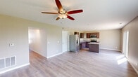 Located at 2575 Gate Dr in Clinton, Iowa, this two-story home offers a well-designed layout across two floors. The main level features an open-concept living and kitchen area with light hardwood-style flooring and a ceiling fan that anchors the spacious living space. Natural light flows in through large windows, offering views of the surrounding greenery. The kitchen is well-appointed with rich dark cabinetry, granite-look countertops, a double-basin sink, and a full suite of stainless steel appliances including a refrigerator with ice maker, electric range, and over-the-range microwave. A hallway on the main level provides access to additional rooms, including a dedicated laundry room equipped with a washer and dryer. Carpeted stairs lead to the upper floor, where all three bedrooms are located. The generously sized primary bedroom includes a walk-in closet with built-in wire shelving and a window for natural light. The additional bedrooms feature plush carpet, large windows with outdoor views, and ample space. Two full bathrooms and hallway access complete the upper level. Clean, neutral finishes and a functional floor plan make this home practical and move-in ready.