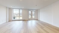 Located at 550 Avenue Delmar in Pointe-Claire, this modern two-storey unit offers 2 bedrooms and 2 bathrooms thoughtfully distributed across two equally sized floors. The contemporary design is defined throughout by light hardwood flooring, clean white walls, and an overall bright, minimalist aesthetic.

The main floor hosts an open-concept kitchen and living area. The kitchen is outfitted with light wood cabinetry paired with white upper cabinets, a sleek subway tile backsplash, stainless steel appliances including a range, dishwasher, and refrigerator, and a undermount sink. The living area is generously proportioned and bathed in natural light through large floor-to-ceiling windows and glass French doors that open to the outdoors, offering views of the surrounding neighbourhood. A hallway and closet complete the main level.

Upstairs, the two bedrooms provide comfortable retreats, with the primary bedroom benefiting from large windows and direct access to a private balcony. The second full bathroom on this level features a soaking tub with a beige tiled surround and a handheld shower fixture. The main-floor bathroom includes a floating wood-toned vanity with a mirrored medicine cabinet. A dedicated in-unit laundry room with side-by-side washer and dryer adds everyday convenience.