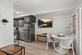 Open-concept kitchen and dining area with modern finishes. - The Ruby Apartments