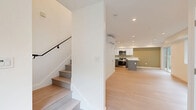 Located at 737 1/2 S Genesee Ave in the heart of Los Angeles, this contemporary two-story home offers 2 bedrooms and 3 bathrooms across two well-proportioned floors. Light wood flooring runs throughout, creating a bright, cohesive aesthetic that complements the clean white walls and recessed lighting found in every room.

The main floor centers around a thoughtfully designed kitchen featuring two-tone cabinetry — white upper cabinets paired with gray lower cabinets — topped with crisp white quartz countertops. Stainless steel appliances, including a gas range, built-in microwave, and a full-size refrigerator, complete the space. A peninsula island provides additional prep and seating space. An accent wall in muted olive adds warmth to the open living area.

Upstairs, both bedrooms are bright and well-sized, each equipped with wall-mounted mini-split climate control units for individual comfort. The spacious primary bedroom includes a mirrored closet with gold-tone framing. The second bedroom features a soft blue accent wall and a window with views of surrounding greenery.

The three bathrooms are finished with clean white subway tile, soaking tubs, and brushed gold fixtures, alongside a separate bathroom featuring a dark-countered vanity with modern tile flooring. A staircase with a sleek metal handrail connects the two floors, enhancing the home's modern character.