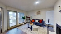This single-story unit in Dallas, Texas offers a thoughtfully designed layout that maximizes its compact footprint. The living room serves as the heart of the home, featuring warm wood-look flooring, neutral walls, and a white-surround fireplace that adds a classic focal point to the space. Large windows fitted with blinds allow natural light to filter in, while a glass-panel door provides direct access to a private outdoor area, enhancing the sense of openness.

The kitchen is efficiently arranged with gray cabinetry, stainless steel appliances including a microwave and electric range, and a granite-topped peninsula that doubles as a breakfast bar and additional prep surface. The layout connects smoothly to the living area, supporting an open and social atmosphere.

The bedroom is a comfortable retreat, accommodating a full-sized bed with room to spare. A ceiling fan overhead, a window with outdoor views, and a private door to the exterior patio add both comfort and functionality. The textured ceiling and wood-look flooring continue the cohesive design aesthetic found throughout the unit. Overall, the space offers a clean, modern feel well-suited for everyday living.