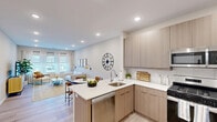 Located at 347 Dover Rd in South Toms River, NJ, this thoughtfully designed 2-bedroom, 3-bathroom single-story home offers a clean, contemporary aesthetic throughout. Light wood-style flooring flows seamlessly across the open-concept living and kitchen area, creating a cohesive and airy feel. The kitchen is equipped with stainless steel appliances, light wood cabinetry, white quartz countertops, a single-basin sink, and recessed lighting — delivering both style and function. The adjoining living room features neutral walls and recessed lighting, providing a comfortable, versatile space. The spacious primary bedroom receives natural light through a large window with sheer curtains and includes dedicated closet storage. The second bedroom is equally well-sized, with access to a closet and a nearby hallway bath. The home includes three bathrooms, each finished with large-format tile flooring and modern wood vanities with white countertops. One bathroom features a glass-enclosed walk-in shower with white subway tile surround. A walk-in closet with built-in shelving and hanging rods provides generous storage. The hallway connects all areas efficiently, completing a well-organized and move-in-ready floor plan.