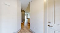 Located at 391 Schultz Rd in Buffalo, NY, this well-appointed single-floor unit offers a thoughtfully designed layout with one bedroom and two full bathrooms. The open-concept living room features light hardwood flooring, recessed lighting, a ceiling fan, and a sliding glass door that floods the space with natural light and provides outdoor access. The kitchen is a standout feature, showcasing white shaker cabinetry, a classic subway tile backsplash, granite countertops, a peninsula with an undermount sink, pendant lighting, and a full suite of stainless steel appliances including a range, microwave, dishwasher, and refrigerator. The bedroom is a comfortable retreat with plush wall-to-wall carpeting, a ceiling fan, and a window with outdoor views. Both bathrooms are finished with the same white cabinetry and granite countertops found in the kitchen, with light hardwood-style flooring and clean, neutral walls. One bathroom includes a soaking tub with a shower curtain rod. Throughout the unit, a consistent neutral color palette, modern hardware, and quality finishes create a cohesive and contemporary aesthetic.