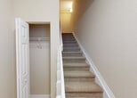 Located at 11338 SW 45th Street in Miramar, Florida, this two-story home offers a well-organized layout across two levels connected by carpeted stairs with white railings and a convenient storage closet at the base. The main level features an open-concept living and kitchen area finished with large neutral-toned ceramic tile flooring throughout. The kitchen is equipped with dark espresso cabinetry, granite countertops, stainless steel appliances including a refrigerator and range, a double sink, and a central island with a breakfast bar overhang — ideal for both cooking and casual dining. Crown molding and recessed lighting add a polished finish to the main living area, which is bright and spacious with room for generous furnishings. A half bathroom on the main level includes a dark wood vanity with a granite countertop and a medicine cabinet mirror. The upper level hosts carpeted bedrooms, including a generously sized room with multiple windows, crown molding, and a ceiling fan that invites abundant natural light. A full bathroom upstairs features a tub/shower combination, dark vanity with granite countertop, and tile flooring. An in-unit laundry closet with full-size washer and dryer hookups adds everyday convenience to this well-appointed Miramar home.