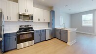 Located in Austin, TX, this single-floor, 3-bedroom, 2-bathroom residence offers a well-designed layout with modern finishes throughout. Light wood laminate flooring flows consistently across all living areas and bedrooms, creating a warm and cohesive aesthetic.

The kitchen is a standout feature, showcasing a two-tone cabinet design with white upper cabinetry and slate-blue lower cabinets, complemented by white quartz countertops, a white subway tile backsplash, and a full suite of stainless steel appliances including a refrigerator, electric range, microwave, and dishwasher. A peninsula with an undermount sink adds functional workspace and an open connection to the adjacent living area.

The three bedrooms are well-proportioned and bathed in natural light through blinded windows offering outdoor views. The primary bedroom features a double-door closet, providing ample storage. Additional bedrooms share the same clean, neutral palette with soft gray walls and bright white trim.

Both bathrooms are finished with large-format light tile flooring, slate-blue vanities topped with marble-style quartz counters, framed mirrors, and shower/tub combinations. The consistent design language throughout the home ties each space together with a clean, contemporary feel suited for modern living in the heart of northwest Austin.