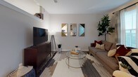Located at 99 WestEdge St in Charleston, SC 29403, this single-floor residence offers a thoughtfully designed open-concept layout that seamlessly connects the living and kitchen areas. The living room features neutral-toned walls, wood-look flooring, and large windows that allow natural light to fill the space, creating a bright and welcoming atmosphere.

The kitchen is outfitted with modern white cabinetry, open shelving, a classic white subway tile backsplash, and a full suite of stainless steel appliances including a refrigerator, electric range, microwave, and dishwasher. Light wood-look flooring and clean countertops complete the contemporary aesthetic.

The bedroom is a comfortable retreat featuring plush carpeting, a ceiling fan with light fixture, and soft neutral walls that contribute to a calm and restful environment. The bathroom is finished in a clean, all-white palette with a soaking tub, shower with curtain, a single-sink vanity with ample cabinet storage, and tile flooring.

A standout practical feature is the in-unit stacked washer and dryer, conveniently located in a dedicated closet just off the kitchen. The overall design of the space is cohesive and modern, combining functionality with understated contemporary style throughout.