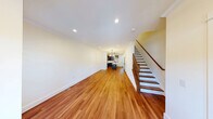 Located at 327 W 5th Ave in Flint, MI, this three-story home offers a well-organized layout across its floors, totaling a comfortable and functional living space. The main level features a combined kitchen and living area, where the kitchen stands out with rich dark-stained cabinetry, stainless steel appliances, a marble-style quartz island with a matte black faucet, and elegant pendant lighting — all accented by crown molding. Warm hardwood flooring flows throughout the main and upper living areas, complemented by recessed lighting and large windows that invite natural light.

The upper floor houses two bedrooms, including a generously sized primary bedroom. Both bedrooms feature plush carpeting, built-in closets with bifold doors, and clean white walls that create a bright, neutral atmosphere. The two bathrooms are finished with neutral tones and matte black fixtures for a modern touch.

A standout feature is the upper-level deck, accessible from the home, offering open views of mature trees and the surrounding neighborhood under an open sky. The unfinished basement spans two sections and provides substantial storage or future finishing potential, currently housing the home's mechanical systems including the water heater and HVAC components.