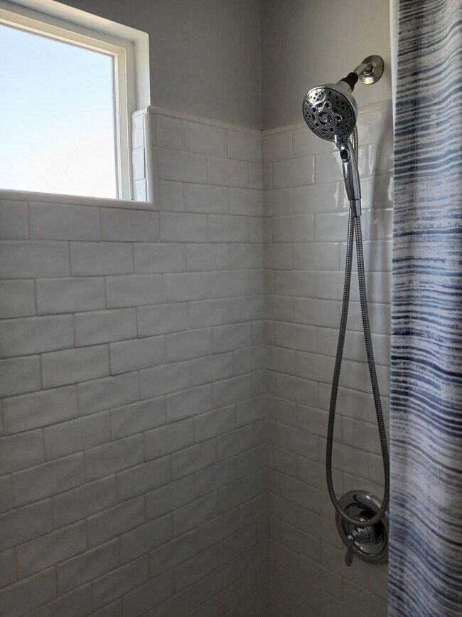 Shower with tile and Kohler cast iron white tub - 1526 N Buena Vista St