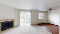 Located in Vancouver, WA, this two-story, two-bedroom, one-bathroom home offers a comfortable and functional layout spread across two floors. The main level welcomes you with a spacious living room bathed in natural light from large sliding glass doors that open to a private balcony, offering pleasant outdoor views. A tile-surround fireplace serves as a focal point in the living area, which features soft wall-to-wall carpeting and a baseboard heating system. The main floor also includes a well-appointed galley-style kitchen with rich dark cabinetry, wood-look flooring, and stainless steel appliances including a range, microwave, and refrigerator. A dedicated in-unit laundry area is conveniently located just off the kitchen. A carpeted staircase leads to the upper level, where both bedrooms are situated. The generously sized primary bedroom features plush carpeting, a large closet, and a bright window. The second bedroom is equally comfortable, complete with its own closet and carpeted flooring. The clean, neutral color palette throughout the home creates a bright and welcoming ambiance, making it a versatile and move-in-ready space.