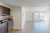 Located at 80 E Hancock St in Detroit's vibrant Midtown district, this efficiently designed unit offers a practical and well-organized single-floor layout. The open-concept living area is bathed in natural light streaming through a large window that frames views of the Detroit cityscape, creating a bright and airy atmosphere despite the compact footprint. Light-toned tile flooring runs throughout, lending a clean and cohesive look to the space.

The kitchen is thoughtfully appointed with dark espresso cabinetry providing ample storage, granite countertops, a classic white subway tile backsplash, and stainless steel appliances including a range and refrigerator — all efficiently arranged to maximize functionality within a compact footprint. A range hood and under-cabinet space complete the well-equipped cooking area.

The bathroom features a matching dark vanity with a granite countertop, a large mirror with overhead lighting, and a full tub/shower combination with grab bars, offering both style and practicality. White walls and neutral tile maintain a clean, cohesive aesthetic throughout.

Additional features include a dedicated closet for storage, a textured ceiling, and an entrance area. The unit's elevated position provides sweeping views of the surrounding Midtown neighborhood, making it an ideal urban retreat.