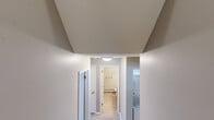 Located at 2845 Englewood Avenue Southeast in Grand Rapids, Michigan, this single-floor, two-bedroom, one-bathroom unit offers a well-organized layout with a practical mix of living spaces. The open-concept living, dining, and kitchen area serves as the heart of the home, featuring light-toned luxury vinyl plank flooring and a neutral gray color palette that creates a bright, cohesive feel. The kitchen is equipped with stainless steel appliances — including a refrigerator, electric range, built-in microwave, and dishwasher — complemented by light wood cabinetry, white countertops, and a double-basin sink with a peninsula that opens to the living and dining area. Both bedrooms are carpeted and offer a comfortable, quiet retreat, with the primary bedroom providing a generous footprint. Multiple closets throughout the unit ensure ample storage. A central hallway connects the bedrooms to the full bathroom, which includes a tub/shower combination, wood-toned vanity, white countertop, and baseboard heating. A convenient in-unit stacked washer and dryer is tucked into the hallway. The textured ceilings and clean white trim add a classic finishing touch throughout the space.