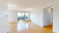 Located on the fourth floor at 110 Park Rd N in Oshawa, Ontario, this well-laid-out 2-bedroom, 1-bathroom unit offers a comfortable and functional living environment. The warm parquet hardwood flooring flows consistently throughout all rooms, lending a cohesive and classic character to the space.

The bright and open living area is a highlight, featuring large sliding glass doors that lead to a private balcony with glass railings and pleasant views of the surrounding neighbourhood, greenery, and open sky. A secondary window further enhances natural light in the living space.

The kitchen is partially enclosed by a half-wall, creating a semi-open layout with white cabinetry, stainless steel appliances including a refrigerator and range, and a tile backsplash. This design keeps the kitchen connected to the main living area without sacrificing definition.

The primary bedroom is generously proportioned and features a bright window that allows natural light to fill the room. The second bedroom includes a sliding door closet, offering practical built-in storage. Both bedrooms maintain the same warm parquet flooring found throughout the unit.

The bathroom is clean and bright, featuring white subway tile surrounding a full soaker tub and shower combination, complemented by chrome fixtures and a marble-style tile floor. Multiple hallways and a dedicated closet provide additional storage and circulation throughout the unit.
