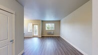 Located at 5715 Red Leaf Dr S in Salem, Oregon, this two-bedroom, two-bathroom unit offers a well-designed single-level layout with a clean, modern aesthetic throughout. The kitchen serves as a standout feature, showcasing rich dark-stained cabinetry, crisp white countertops, and a full suite of stainless steel appliances including a gas range, microwave, and refrigerator. A central island provides additional prep space and casual seating, while pendant lighting and a chandelier add warmth and character to the space. Light wood-style luxury vinyl plank flooring runs through the main living areas, offering both durability and visual appeal. The combined kitchen and living area creates an open, functional flow ideal for everyday living. Both bedrooms are carpeted and offer a quiet, comfortable retreat, with closet storage and neutral wall tones. The primary bedroom includes a ceiling fan and a window that brings in natural light. Each bathroom is finished with dark vanity cabinetry, white countertops, and a tub/shower combination. The second bathroom also features a grab bar for added accessibility. Overall, the unit presents a consistent, contemporary finish package with practical features throughout.
