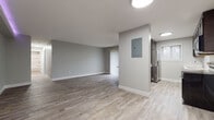 Located at 6416 Stumph Rd in Parma Heights, Ohio, this single-floor unit has been thoughtfully renovated with contemporary finishes and a cohesive neutral palette. Light wood-look luxury vinyl flooring runs throughout the entire space, complemented by crisp white baseboards and soft gray walls that create a clean, modern aesthetic.

The open living area is generously proportioned, offering flexible furniture arrangements and seamless flow between spaces. Recessed and flush-mount ceiling lighting ensures consistent illumination, while an accent LED strip light in a secondary living zone adds a distinctive modern touch. An electrical panel is conveniently accessible within the main living space.

The kitchen is well-appointed with dark espresso cabinetry, light quartz countertops, a stainless steel refrigerator, dishwasher, electric range, and built-in microwave. A single window above the sink allows natural light to brighten the workspace.

The bedrooms are well-sized, with one featuring a dedicated closet with a hanging rod and natural light from a window with blinds. The bathroom includes a full tub-shower combination, a dark-cabinetry vanity with a light countertop, and wood-look flooring that ties into the rest of the unit's design.