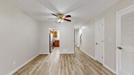 Located in Columbus, OH, this two-story residence offers a well-organized layout across two floors, accommodating two bedrooms and two full bathrooms. The main floor features a bright and open living room with light hardwood-style flooring, neutral walls, and a ceiling fan with integrated lighting. A sliding glass door floods the space with natural light and provides access to an outdoor area. The kitchen is efficiently designed with warm wood cabinetry, granite-style countertops, and stainless steel appliances including a refrigerator, gas range, and sink with a window above. A hallway connects the main living areas and leads to the carpeted staircase with a black metal railing. Upstairs, two bedrooms are finished with plush wall-to-wall carpeting and natural light from windows, offering a comfortable and quiet retreat. The generously sized primary bedroom provides ample space for furnishings. Both bathrooms feature wood-toned cabinetry with granite-style countertops and light hardwood-style flooring, maintaining a cohesive aesthetic throughout. Clean white trim, neutral tones, and consistent finishes lend a fresh, move-in-ready feel to the entire home.