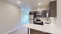 Located at 6200 East 3rd Street in Superior, Wisconsin, this thoughtfully designed 2-bedroom, 2-bathroom unit offers a comfortable and modern living experience across a single floor. Light-toned luxury vinyl plank flooring flows throughout, lending a clean, cohesive look to every room.

The kitchen serves as a functional centerpiece, featuring dark espresso cabinetry, crisp white countertops, stainless steel appliances, a built-in sink with a matte black faucet, and a peninsula with bar seating that opens to the main living area. Recessed lighting adds a polished touch overhead.

Both bedrooms are well-proportioned, with the primary bedroom offering a dedicated closet and a wall-mounted mini-split system for individualized climate control. Each bedroom is brightened by large windows that frame peaceful views of the surrounding greenery and open landscape. Baseboard heating provides additional warmth throughout the cooler months.

The two bathrooms are finished consistently with white tub-shower combinations, dark-accented curved curtain rods, white countertops, and wood-toned vanities that complement the overall aesthetic. Each bathroom is clean and efficiently laid out.

A dedicated closet provides practical storage within the unit. The overall design balances modern finishes with functional layouts, making this Superior, WI unit a well-appointed and inviting space.