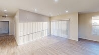 This contemporary apartment offers 1260 square feet of well-designed living space on a single floor. The open-concept layout seamlessly integrates the kitchen, living, and dining areas, creating a spacious and airy ambiance. The kitchen is a highlight, featuring light wood cabinetry, stainless steel appliances, and a center island with a sink, perfect for meal preparation and casual dining.

Both bedrooms are generously sized, with the primary bedroom boasting 210 square feet. Large windows in the bedrooms and living areas flood the space with natural light, while also offering views of the surroundings. The apartment includes two modern bathrooms, one of which is shown with accessible features such as grab bars.

Throughout the apartment, neutral tones dominate, with light carpeting in the bedrooms and wood-look flooring in the main living areas and bathrooms. Recessed lighting and ceiling fans add to the modern aesthetic. Ample storage is provided through built-in closets with adjustable shelving.

The overall design emphasizes functionality and comfort, making efficient use of the available space while maintaining an open and inviting atmosphere. This apartment would be ideal for those seeking a contemporary living space in an urban setting.