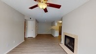 This single-floor, two-bedroom, two-bathroom residence in Jackson, Tennessee offers a well-organized layout with a mix of practical finishes and comfortable living spaces. The living room serves as the focal point of the home, featuring a tile-surround fireplace, wood-look laminate flooring, a ceiling fan with light fixture, and a window that allows natural light to fill the space. A half-wall peninsula separates the living area from the kitchen, which is equipped with stainless steel appliances including a refrigerator, range, and microwave, complemented by white cabinetry and light countertops. The kitchen also features wood-look flooring consistent with the main living area.

Both bedrooms are carpeted and offer a comfortable, quiet retreat. Each includes a walk-in or standard closet with built-in shelving, and windows that bring in natural light. The two bathrooms are finished with tile flooring, white vanities, and grab bars for added accessibility. A hallway connects the bedroom wing to the main living area, providing clear circulation throughout. Textured ceilings are present throughout the unit, contributing to its traditional character.