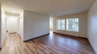 Located in University Place, WA, this single-floor, three-bedroom, two-bathroom home offers a functional and comfortable layout. The living room is bright and welcoming, featuring wood-style plank flooring, a textured ceiling, baseboard heating, and a wide multi-pane window that frames views of mature trees outside, filling the space with natural light.

The galley-style kitchen is efficiently designed with ample white cabinetry, white countertops, a stainless steel sink, and full-size white appliances including a refrigerator, range, and dishwasher. The wood-style flooring continues throughout the kitchen, reinforcing a cohesive aesthetic.

All three bedrooms are carpeted and feature textured ceilings, baseboard heating, and windows that bring in natural light. The spacious primary bedroom includes a sliding double-panel closet door for storage. The additional bedrooms are well-proportioned and versatile.

The two bathrooms are finished with wood-style flooring and light neutral tones. One bathroom features a white vanity with modern cabinetry, while the other includes a full bathtub with grab bars and a small privacy window. Both bathrooms are clean and practical in design.

Overall, the home presents a neutral, move-in-ready aesthetic with consistent finishes throughout.