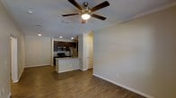 This 1-bedroom, 1-bathroom residence offers a smartly designed single-floor layout that maximizes both comfort and functionality. The open-concept living and kitchen area creates a seamless flow, anchored by rich hardwood-style flooring that runs throughout the main living space. Crown molding adds a refined touch, while recessed lighting and a ceiling fan with a built-in light fixture ensure the space remains bright and comfortable year-round.

The kitchen is a standout feature, showcasing dark espresso cabinetry that contrasts beautifully with light-toned countertops. A peninsula with an overhang provides additional seating and prep space, making it ideal for casual dining or entertaining. Stainless steel appliances, including a refrigerator, microwave, and range, complete the contemporary kitchen setup.

The living area is generously proportioned, offering ample room for a variety of furniture arrangements. Neutral wall tones provide a versatile backdrop that complements any décor style. An interior door leads to additional private spaces, maintaining a clear separation between living and personal areas. The overall ambiance is clean, modern, and move-in ready, making this a highly functional and attractive single-floor home.