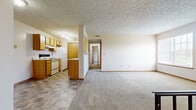 Located at Emerald Lakes Blvd in Powell, Ohio, this single-floor residence offers a practical and well-organized layout with two bedrooms, one full bathroom, and a dedicated laundry area. The open-plan kitchen and living room form the heart of the home, with the galley-style kitchen featuring warm oak cabinetry, white appliances including a range and refrigerator, light countertops, and tile flooring under track lighting. The kitchen flows naturally into the carpeted living area, which receives natural light through a large window. Textured ceilings are consistent throughout the home, lending a classic residential character. The primary bedroom is generously sized and includes a large walk-in closet outfitted with dual shelving units on opposing walls, providing ample storage. The second bedroom also features carpet, a sliding-door closet, and access to the hallway. Both bedrooms are bright and neutral in tone. The full bathroom is well-appointed with a single-sink oak vanity, white countertop, tiled flooring, and a full soaking tub with shower. Two hallways connect the rooms efficiently, and the inclusion of a laundry area adds everyday convenience to this functional Powell residence.