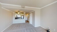Located at 30331 Via Reata in Laguna Niguel, California, this two-story home offers a well-designed layout suited for comfortable everyday living. The main level features an open-concept living and dining area finished with plush wall-to-wall carpeting, crown molding, a ceiling fan, and a cozy fireplace. The kitchen is thoughtfully appointed with white shaker-style cabinetry, dark countertops, a stainless steel refrigerator, electric range, built-in microwave, dishwasher, and a double-basin sink — all visible from the living area through a convenient pass-through counter. Natural light filters in through multiple windows, creating a bright and welcoming atmosphere throughout. A dedicated in-unit laundry closet houses a full-size washer and dryer, adding everyday convenience. Upstairs, the bedrooms are carpeted and generously sized, with vaulted ceilings and large windows that invite abundant natural light and views of the surrounding neighborhood. One bedroom features a wide double-door closet. The bathroom includes a single-vanity with dark countertop, a full tub-shower combination, and a large mirror. The home's neutral color palette and clean finishes provide a versatile canvas throughout both levels.