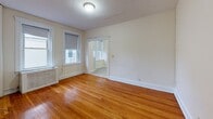 Located at 127 Washington St in Boston, MA, this single-floor unit offers a practical and classic layout with well-maintained interiors throughout. Warm hardwood floors extend across the living and bedroom areas, lending a timeless character to the space. The living room features multiple windows fitted with roller shades, allowing for controlled natural light, and is equipped with a classic cast-iron radiator that reflects the building's traditional heating system. An open doorway connects the living area to an adjoining room, enhancing the sense of flow throughout the unit. The bedrooms are generously sized, each with hardwood flooring, white-trimmed doors, and built-in closet storage. The kitchen is efficiently designed with white cabinetry, a gas range, a full-size refrigerator, and tile flooring, providing all essential cooking amenities in a compact, organized space. The bathroom is finished with tile flooring, a vanity with under-sink storage, a mirrored medicine cabinet, and a shower-tub combination, maintaining a clean, functional aesthetic. The overall ambiance of the unit is light and neutral, with white walls throughout that offer a clean, move-in-ready backdrop. This residence combines classic Boston architectural details with practical, everyday functionality.