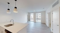 Located at 736 E McMillan St in Cincinnati's vibrant Evanston neighborhood, this single-floor residence offers a thoughtfully designed open-concept layout with modern finishes throughout. The living area is bright and airy, featuring light wood-look flooring, recessed lighting, and large windows paired with a glass balcony door that floods the space with natural light and provides direct access to a private outdoor balcony with neighborhood views. Pendant lighting above the kitchen counter adds a contemporary touch to the seamless transition between the living and kitchen areas. The kitchen is well-appointed with crisp white shaker-style cabinetry, light quartz countertops, and a full suite of stainless steel appliances, including a range, over-the-range microwave, and refrigerator. The bedroom features soft carpeting, a bold gray accent wall, and a generous window that brings in additional natural light. The bathroom is clean and functional, outfitted with wood-look flooring, a white vanity with an undermount sink, a full soaking tub with shower, and chrome fixtures. Throughout the space, a neutral white and light gray color palette creates a cohesive, modern ambiance that is both welcoming and easy to personalize.