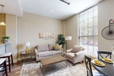 Located at 12 Eagle St in Providence, Rhode Island, this well-appointed two-bedroom, two-bathroom residence offers a thoughtfully designed single-floor layout. A welcoming hallway with hardwood flooring and recessed lighting leads into the main living areas. The combined living and dining room is a standout feature, boasting impressively tall windows that flood the space with natural light and create an airy, open atmosphere. The kitchen features granite countertops, white cabinetry, stainless steel appliances, and a breakfast bar with seating — ideal for casual dining. The primary bedroom is generously sized, offering a walk-in closet and large windows with outdoor views. The second bedroom also benefits from ample natural light and includes closet storage. Both bathrooms are well-finished; one includes a granite-topped vanity with a vessel sink, while the other features a full tub-shower combination. Warm, neutral tones carry throughout the residence, complemented by hardwood floors in the main areas and carpet in the bedrooms. Additional conveniences include a dedicated laundry area, utility room, and multiple closets providing excellent storage. The overall ambiance is clean, modern, and comfortable.