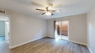 Located at 520 S Carroll Blvd in Denton, TX, this single-story 2-bedroom, 1-bathroom home offers a well-organized layout across a comfortable footprint. The interior features consistent wood-look plank flooring throughout, paired with neutral light gray walls that create a clean, cohesive aesthetic.

The living areas are bright and open, each equipped with ceiling fans and lit by natural light. One living area includes a sliding glass door that opens to a fenced outdoor patio, providing a private exterior space. A second living area features a front entry door and its own ceiling fan with light fixture.

The galley-style kitchen is efficiently designed with white cabinetry, white countertops, a stainless steel sink, and white appliances including a refrigerator, electric range, microwave, and dishwasher. A hallway connects the main living spaces to the bedrooms and bathroom.

Both bedrooms include ceiling fans and wood-look flooring. The primary bedroom is generously sized and features two closets, offering ample storage. The second bedroom includes a window with blinds allowing natural light. The shared full bathroom is outfitted with a tub-shower combination featuring white tile surround and chrome fixtures.