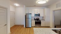 Located at 2815 Coliseum Centre Dr in Charlotte, NC, this single-floor residence offers a well-designed layout with a clean, contemporary aesthetic throughout. The kitchen serves as a functional centerpiece, featuring white cabinetry, granite countertops, stainless steel appliances including a refrigerator, electric range, and built-in microwave, all set atop warm wood-tone flooring that extends through the main living areas. Flush-mount lighting keeps the space well-illuminated.

The open living area continues the wood-tone flooring and includes a ceiling fan, with a window providing natural light and views of the surrounding community. Bedrooms are carpeted for comfort, each equipped with a ceiling fan and a window with blinds that allow in natural light. The layout accommodates multiple bedrooms, each offering a quiet, neutral environment.

Two full bathrooms are finished consistently, each with granite-topped vanities, undermount sinks, chrome fixtures, and a tub/shower combination set over wood-tone flooring. One bathroom provides direct access to a walk-in closet with wire shelving.

A dedicated laundry room houses a full-size washer and dryer, adding everyday convenience. Throughout the unit, neutral tones and consistent finishes create a cohesive, move-in-ready atmosphere.