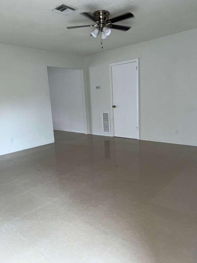 Living room: porcelain floors throughout. Ceiling fan in living room and two bedrooms - 5010 SW 26th Ave