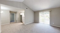 Located at Kimberly Village in Marietta, Georgia, this one-bedroom, one-bathroom residence offers a well-organized single-floor layout designed for comfortable everyday living. The living area greets you with impressively vaulted ceilings that lend an open, airy feel to the space, complemented by soft carpeting underfoot and a sliding door that invites natural light and outdoor access. The galley-style kitchen is thoughtfully appointed with white shaker cabinetry, light countertops, a classic subway tile backsplash, and stainless steel appliances including a refrigerator, electric range, and over-the-range microwave — all illuminated by a skylight panel above. Durable wood-look flooring runs throughout the kitchen, adding warmth and easy maintenance. The generously sized bedroom features plush carpeting, a dedicated closet with louvered doors, and direct access to the full bathroom. The bathroom is clean and functional, equipped with a full-size tub-shower combination and wood-look flooring. A dedicated laundry area houses a full-size GE washer and dryer, adding everyday convenience. Neutral warm-gray tones throughout the home provide a versatile backdrop, while the layout maximizes every square foot for efficient, comfortable living.