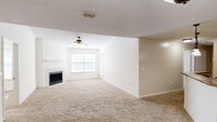This single-floor, 2-bedroom, 2-bathroom residence offers a functional and comfortable layout designed for everyday living. The spacious living room serves as the heart of the home, featuring plush carpeting, a ceiling fan, a tiled fireplace, and a large window that fills the space with natural light. Vaulted ceilings add an airy sense of openness to the living area. The kitchen is well-equipped with white cabinetry, dark granite-style countertops, a tile backsplash, a double-basin sink, a dishwasher, and a peninsula with pendant lighting overhead that connects seamlessly to the living area. A carpeted hallway leads to both bedrooms, each offering comfortable proportions and their own closets. The primary bedroom includes a generous walk-in closet outfitted with wire shelving. Both bathrooms are finished with tile flooring, a tub-shower combination, a single vanity, and updated light fixtures. A dedicated laundry room with tile flooring, built-in shelving, and washer/dryer hookups adds convenient practicality. Throughout the home, textured ceilings, neutral wall tones, and consistent finishes create a cohesive and move-in-ready environment.