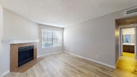 This 2-bedroom, 1-bathroom home in Killeen, TX offers a well-organized single-story layout designed for comfortable everyday living. Throughout the home, light wood-look flooring creates a clean, cohesive aesthetic complemented by neutral, warm-toned walls and white baseboards.

The living room serves as the heart of the space, featuring a tile-surround fireplace with a white mantle and a window fitted with horizontal blinds that allow natural light to filter in. A textured popcorn ceiling adds a classic touch found throughout the home.

The galley-style kitchen is efficiently laid out with dark cabinetry, light countertops, subway tile backsplash, and stainless steel appliances including a gas range and refrigerator. The kitchen connects seamlessly to the main living area, with a pass-through peninsula providing additional counter space.

The spacious primary bedroom offers generous room to furnish comfortably, with a ceiling fan, a natural-light window with blinds, and easy access to additional spaces. The second bedroom is similarly appointed with wood-look flooring, a window, and neutral walls.

A dedicated laundry area houses a full-size washer and dryer unit with overhead shelving for storage. The home's clean, move-in-ready condition and practical layout make it a functional and inviting residence.