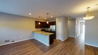 This two-floor home offers a thoughtfully designed layout with a blend of practical functionality and modern finishes throughout. The main level centers around an open-concept kitchen and living area, where rich dark wood cabinetry pairs with granite countertops and a peninsula that doubles as a breakfast bar. Stainless steel appliances, including a French door refrigerator and electric range, are complemented by pendant lighting and recessed fixtures overhead. Durable hardwood-style flooring runs throughout the main living areas, adding warmth and continuity to the space.

The upper level features generously sized bedrooms finished with plush carpeting and neutral-toned walls, offering a comfortable and quiet retreat. The primary bathroom includes a walk-in glass-enclosed shower and a dark wood medicine cabinet, while a secondary full bathroom is equipped with a tub-shower combo and tile flooring. A convenient half bathroom on the main level features a granite-topped vanity and a window that brings in natural light. The dedicated laundry room accommodates a full-size washer and dryer side by side, with built-in shelving above and a window for additional ventilation. Together, these features make for a well-rounded and move-in-ready home.