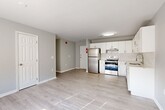 Located at 225 W Fourth St in downtown Wilmington, Delaware, this two-bedroom, two-bathroom residence offers a well-designed single-floor layout. Light wood-style luxury vinyl flooring runs throughout the unit, complementing the neutral gray walls and white trim that create a clean, modern aesthetic.

The kitchen is a standout feature, finished with crisp white cabinetry extending to the ceiling, a subway tile backsplash, light quartz countertops, and a full suite of stainless steel appliances including a refrigerator, electric range, and dishwasher. A flush-mount ceiling light brightens the space, which flows openly into the living area.

The living area is spacious and filled with natural light from a large window, offering a bright and airy atmosphere. The generously sized primary bedroom also benefits from natural light through its own window, providing a comfortable retreat. The second bedroom connects conveniently to the rest of the unit via a classic six-panel white door.

Both bathrooms are finished in the same neutral palette with wood-style flooring and brushed nickel hardware. A dedicated utility closet houses a stacked LG washer and dryer alongside a water heater, offering in-unit laundry convenience. The layout is practical and efficient throughout.