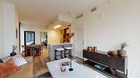 Located in Washington, DC's vibrant NoMa neighborhood, this well-appointed 2-bedroom, 2-bathroom residence offers a thoughtfully designed open-concept layout with contemporary finishes throughout. The living area is anchored by floor-to-ceiling windows that flood the space with natural light and frame views of the surrounding cityscape. Light-toned hardwood flooring flows seamlessly from the living room into the kitchen and dining areas, creating a cohesive and inviting atmosphere.

The kitchen features stainless steel appliances, warm wood cabinetry paired with white upper cabinets, a textured tile backsplash, and a peninsula with bar seating — ideal for casual dining or entertaining. Both bedrooms offer generous proportions, with the primary bedroom benefiting from large windows that bring in ample natural light and urban views. The second bedroom similarly features floor-to-ceiling windows overlooking the street below.

Each bathroom is finished with marble-style tile flooring and floating walnut vanities. The primary bathroom includes a glass-enclosed walk-in shower, while the second bathroom offers a full tub-shower combination. A dedicated closet and hallway complete the functional layout, making this residence a refined and practical home in the heart of Washington, DC.