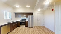 Located at 4142 E Morada Ln in Stockton, California, this single-floor unit offers a thoughtfully designed layout that maximizes its cozy footprint. The open-concept living and kitchen area is anchored by light wood-look flooring that runs throughout, lending warmth and visual continuity to the space.

The kitchen is a standout feature, outfitted with rich dark-brown cabinetry, crisp white countertops, and a full suite of stainless steel appliances including a gas range, built-in microwave, refrigerator, and dishwasher. A deep single-basin sink with a modern faucet sits beneath a window, bringing in natural light. The kitchen flows seamlessly into the living area, which benefits from additional windows and a sliding glass door that invite ample daylight and provide outdoor access.

The bathroom is clean and functional, featuring white shaker-style cabinetry, a warm-toned countertop, a large mirror, and a full tub-shower combination with brushed nickel fixtures. The space also includes a half-wall partition that defines the sleeping area, which is equipped with a ceiling fan and a built-in closet. Flush-mount ceiling lighting throughout ensures consistent illumination. The unit's neutral color palette and modern finishes create a bright, move-in-ready atmosphere.