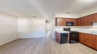 Located at 4050 78th Ave N in Pinellas Park, Florida, this single-floor, 2-bedroom, 1-bathroom unit offers a practical and comfortable layout designed for efficient everyday living. Throughout the space, light-toned luxury vinyl plank flooring and textured ceilings create a consistent, clean aesthetic.

The open-concept living and dining area provides a versatile gathering space, flowing naturally toward the kitchen. The kitchen is well-appointed with warm, rich-toned wood cabinetry extending to the ceiling for generous storage, light granite-style countertops, a decorative tile backsplash, and a full suite of black appliances including a range, microwave, dishwasher, and refrigerator.

Both bedrooms are bright and comfortable, each featuring windows with blinds that allow natural light to filter in. The primary bedroom is a well-proportioned retreat complete with a double-door closet, while the second bedroom offers comparable finishes and ample space. Three closets throughout the unit provide abundant storage.

The bathroom is neatly finished with a wood-toned vanity, granite-style countertop, and a full tub-shower combination with white tile surround. A hallway connects the main living areas to the bedrooms, adding to the unit's logical and functional flow.