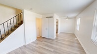 Located at 3779 Swiss Dr in Saint Louis, MO, this three-bedroom, two-bathroom home spans three floors, offering a well-organized and functional layout. Light wood-style flooring runs consistently throughout the space, complemented by crisp white walls and textured ceilings that give each room a clean, bright aesthetic.

The living room provides an open, airy feel with access to the staircase, which features a classic black metal railing with decorative scroll detailing. The kitchen is outfitted with white shaker-style cabinetry, stainless steel appliances including a range and full-size refrigerator, and ample counter space.

The three bedrooms are well-proportioned, each equipped with ceiling fans and natural light from large windows with horizontal blinds that frame neighborhood views. The spacious primary bedroom includes closet access and additional door configurations for added versatility. The secondary bedrooms offer similar finishes in a slightly more compact footprint.

Both bathrooms are finished in a clean, minimal style. One bathroom features a full tub-shower combo with white surround, a vanity with white cabinetry, and wood-style flooring. A utility room and hallway round out the floor plan. Staircases connect all three levels, making the home's vertical layout easy to navigate.